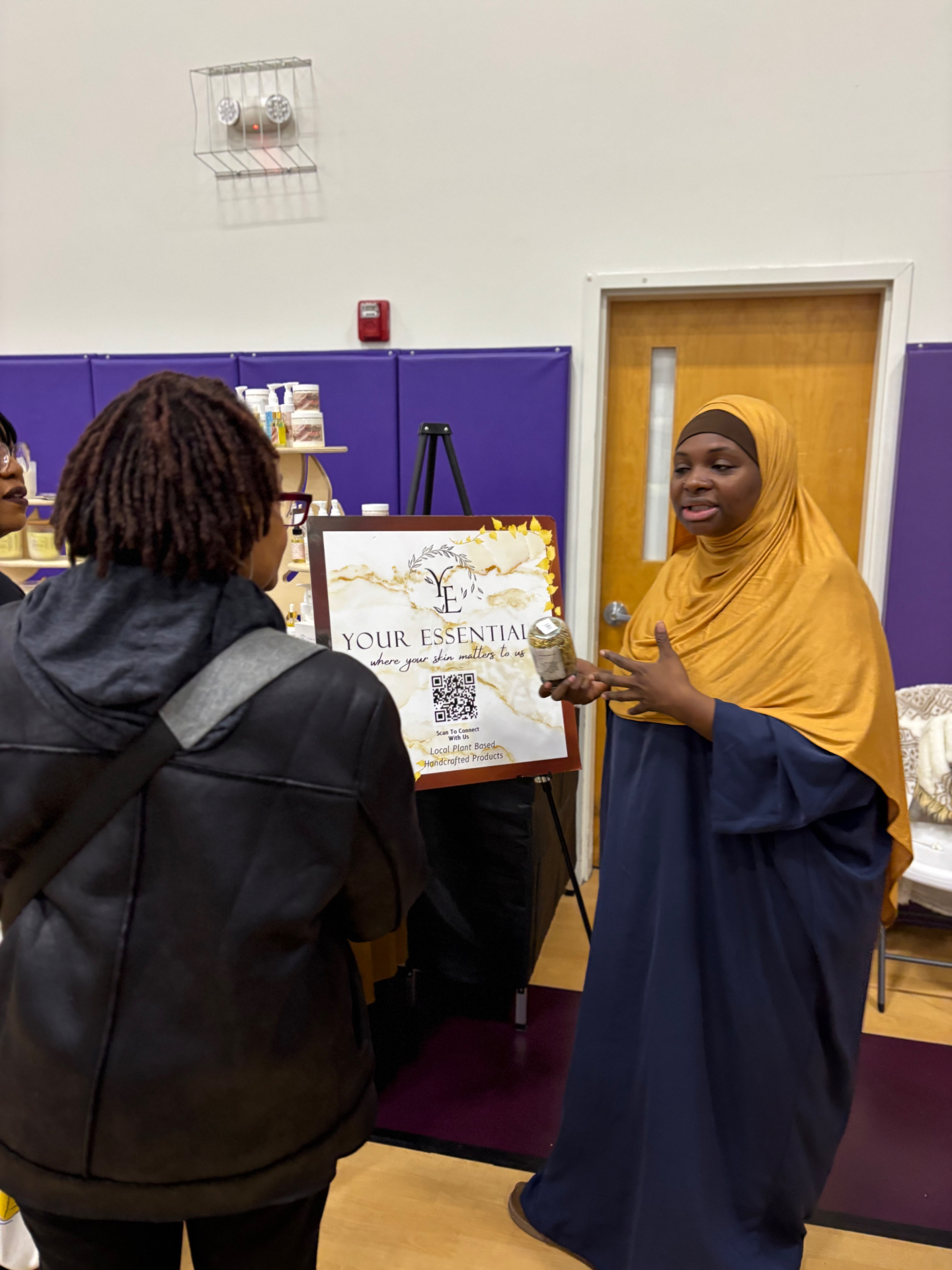 Vendor sharing plant-based skincare products with an attendee