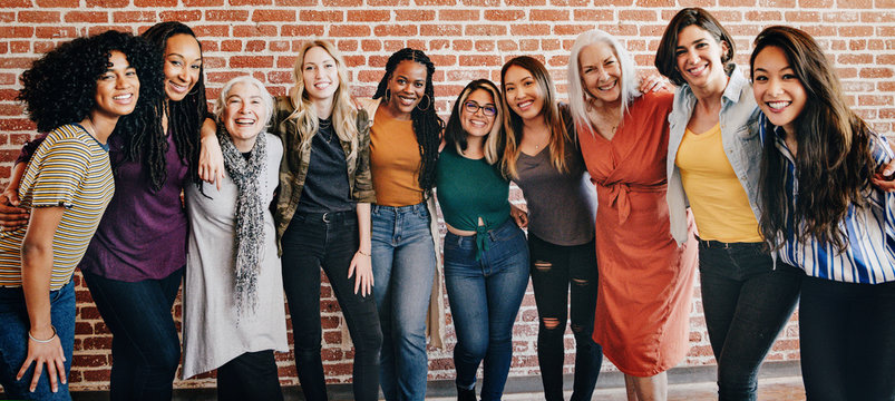 A diverse group of women standing together, smiling